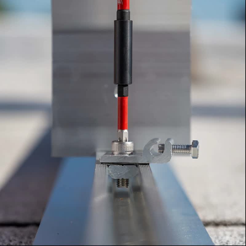 A Mountkit FLAT10 grounding lug clamped to an aluminium solar rail.